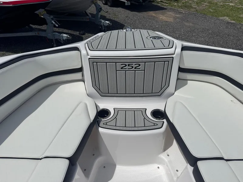 Slide: The Image of 2025 Yamaha Boats 252S interior seating with gray and white upholstery, featuring cup holders. - 7