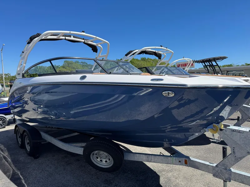 The Image of 2025 Yamaha Boats 252S on trailer, sleek design, blue hull, sunny day. - 0