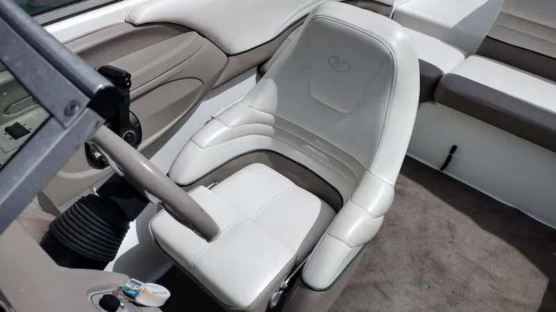 Slide: The Image of 1999 Cobalt 226 boat interior with steering wheel and cushioned seat. - 13