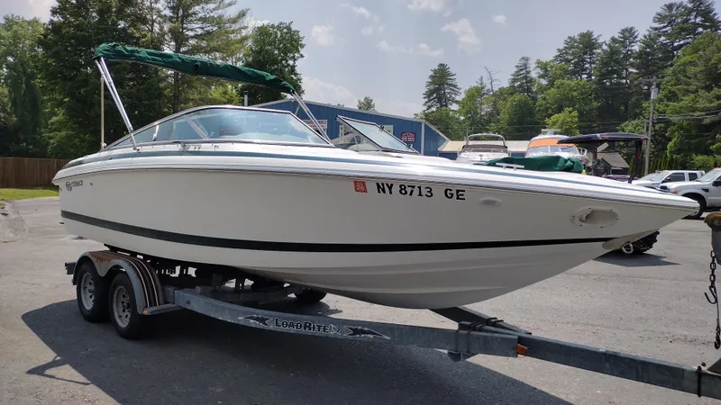 Slide: The Image of 1999 Cobalt 226 boat on trailer, parked outside a storage facility. - 2