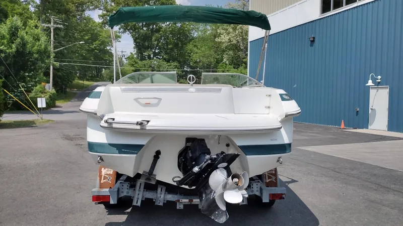 Slide: The Image of 1999 Cobalt 226 boat on trailer, white with green accents, parked outdoors. - 5