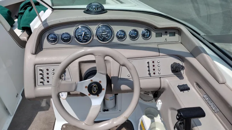 Slide: The Image of Interior of a 1999 Cobalt 226 boat with cushioned seating and cup holders. - 9