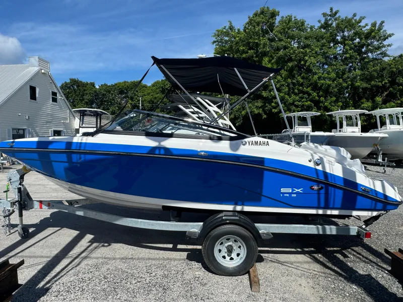 The Image of 2025 Yamaha Boats SX195 in blue on trailer, parked outdoors. - 0
