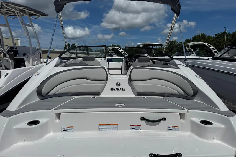 Slide: The Image of 2025 Yamaha Boats SX190 with sleek design, spacious seating, and modern features under a clear sky. - 2
