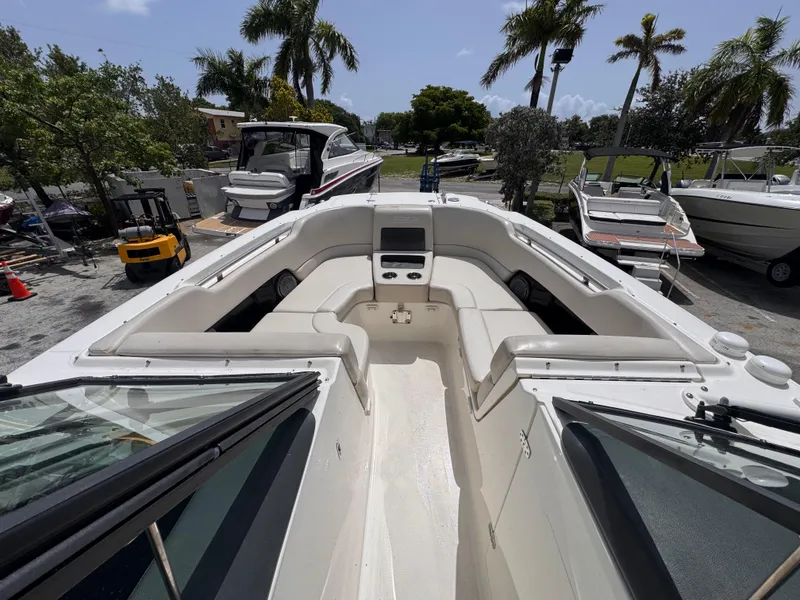 Slide: The Image of 2014 Boston Whaler 270 Vantage boat with spacious seating, docked near palm trees. - 13