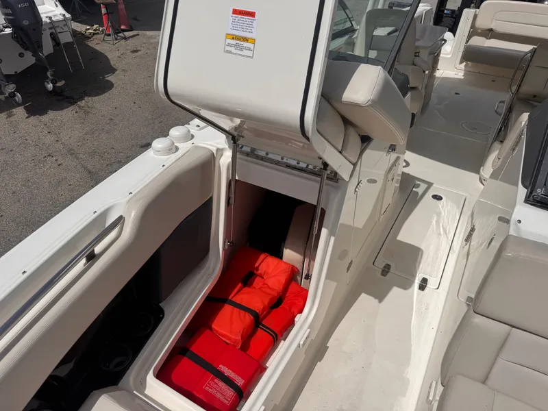 Slide: The Image of 2014 Boston Whaler 270 Vantage boat with open storage compartment and life jackets. - 18