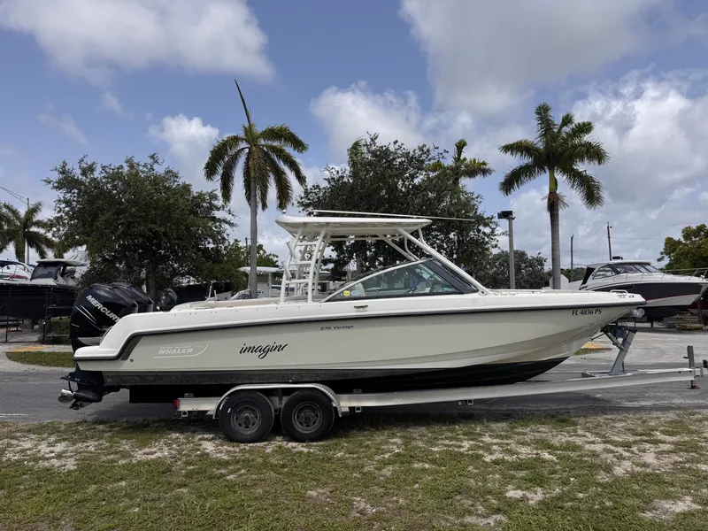 Slide: The Image of 2014 Boston Whaler 270 Vantage boat on trailer, parked near palm trees. - 22