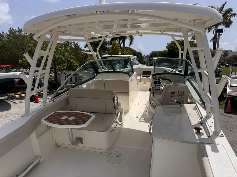 Slide: The Image of 2014 Boston Whaler 270 Vantage boat interior with seating and helm, docked outdoors. - 3