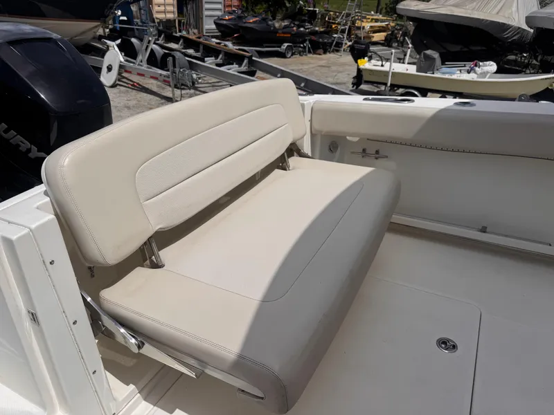 Slide: The Image of 2014 Boston Whaler 270 Vantage boat with beige seating, docked outdoors. - 4