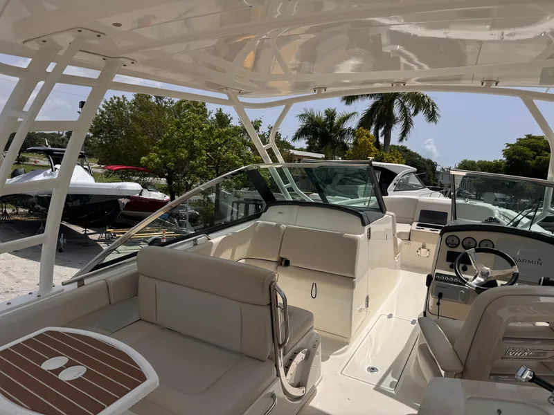Slide: The Image of 2014 Boston Whaler 270 Vantage boat interior with seating and dashboard, under sunny skies. - 6
