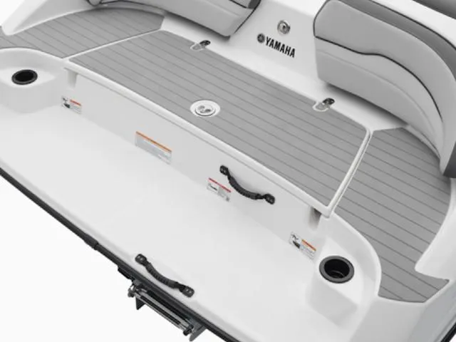 Slide: The Image of 2025 Yamaha Boats SX190 swim platform with gray decking and cup holders. - 23