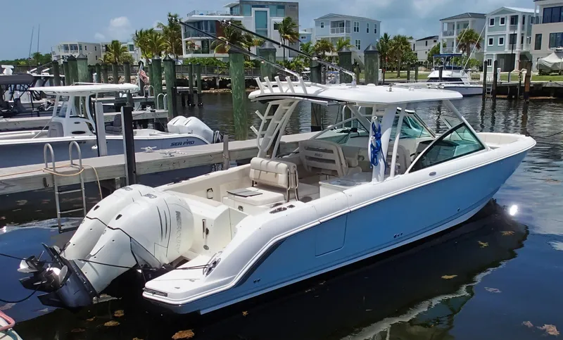 The Image of 2017 Boston Whaler 320 Vantage boat docked in a marina with modern homes in the background. - 0