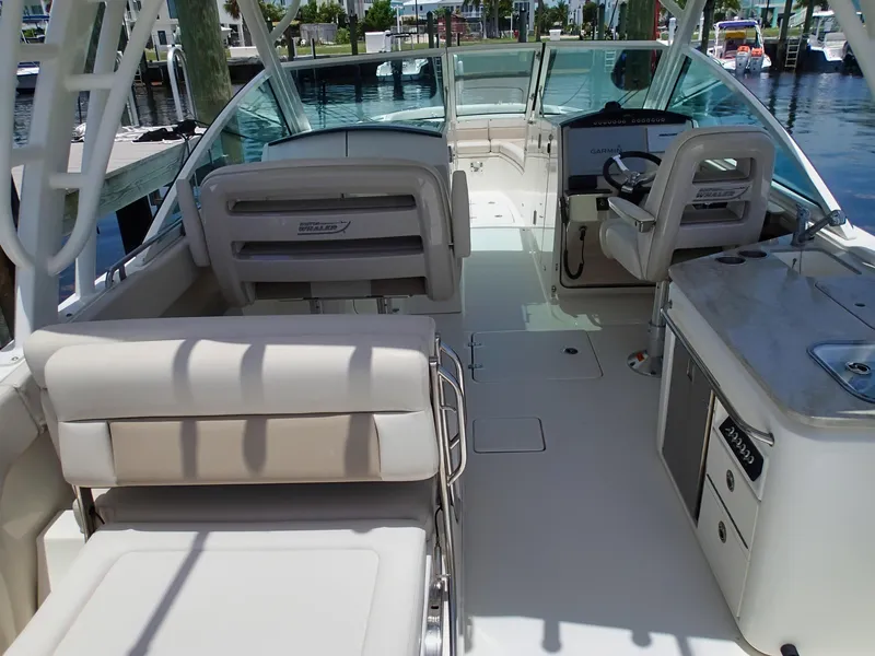 Slide: The Image of 2017 Boston Whaler 320 Vantage boat interior with seating and helm, docked at marina. - 6