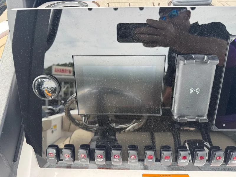Slide: The Image of 2025 Yamaha Boats 255 FSH Sport H dashboard with compass, switches, and touchscreen display. - 21