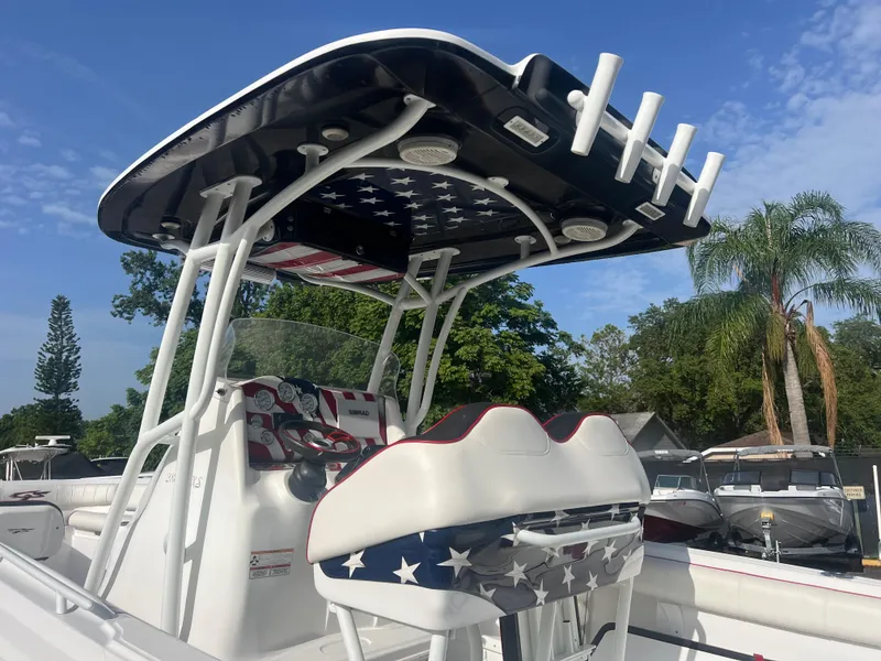 Slide: The Image of 2019 Glasstream 280 Pro-XS boat with American flag-themed seating and canopy, under clear blue sky. - 2
