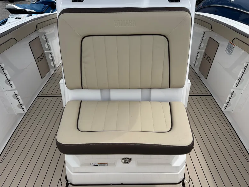 Slide: The Image of 2025 Yamaha Boats 255 FSH Sport H interior seating with beige upholstery and sleek design. - 14