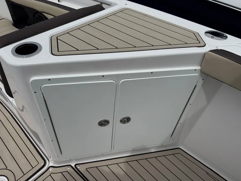 Slide: The Image of 2025 Yamaha Boats 255 FSH Sport H interior with storage compartment and cup holder. - 18