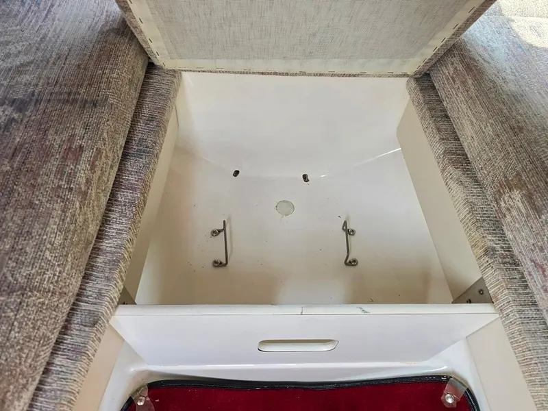 Slide: The Image of 1994 Sea Ray 220 Overnighter storage compartment with open lid, showcasing interior space. - 10