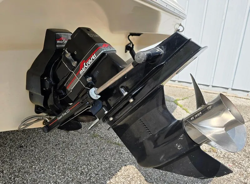 Slide: The Image of 1994 Sea Ray 220 Overnighter boat with MerCruiser outboard motor, parked on gravel. - 14