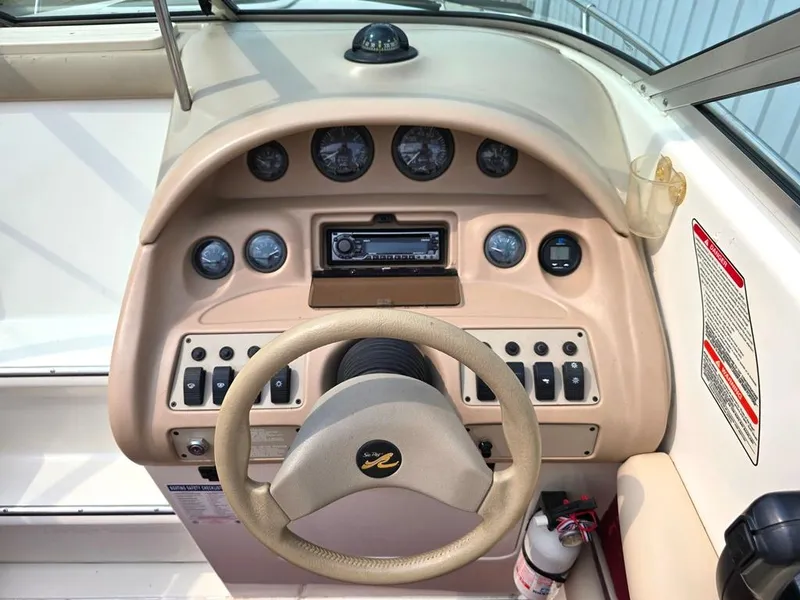 Slide: The Image of 1994 Sea Ray 220 Overnighter dashboard with steering wheel and control panel. - 17