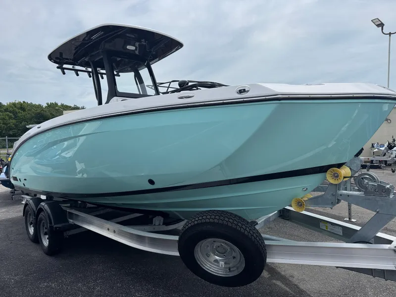 The Image of 2025 Yamaha Boats 255 FSH Sport H on trailer, light blue hull, outdoor display. - 0