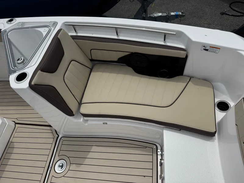 Slide: The Image of 2025 Yamaha Boats 255 FSH Sport H interior seating with beige cushions and cup holders. - 12