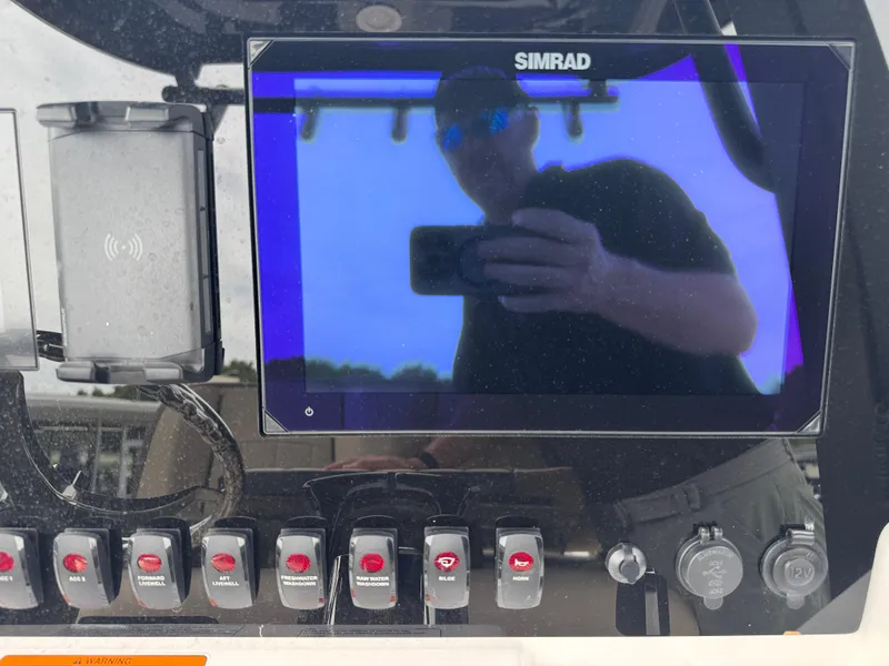 Slide: The Image of Control panel of 2025 Yamaha Boats 255 FSH Sport H with Simrad display and switches. - 20