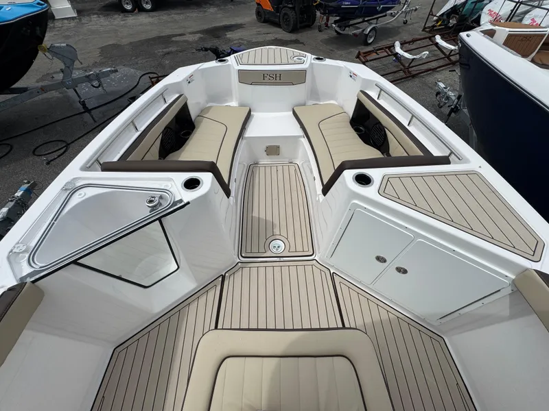 Slide: The Image of 2025 Yamaha Boats 255 FSH Sport H interior with cushioned seating and storage compartments. - 7