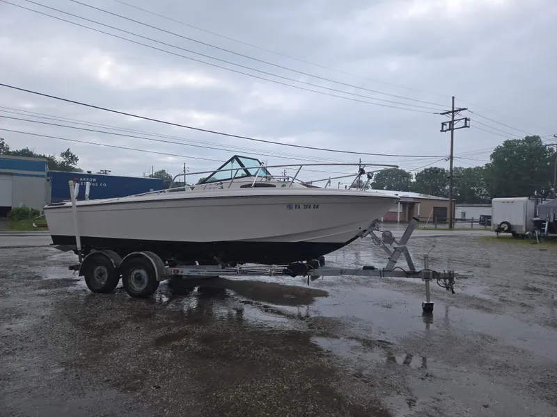 The Image of 1992 Dixie 21 boat on trailer in a parking lot, overcast sky. - 1