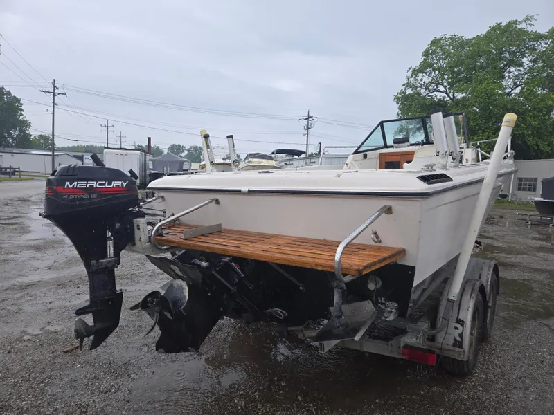 Slide: The Image of 1992 Dixie 21 boat with Mercury outboard motor on a trailer in a parking lot. - 4