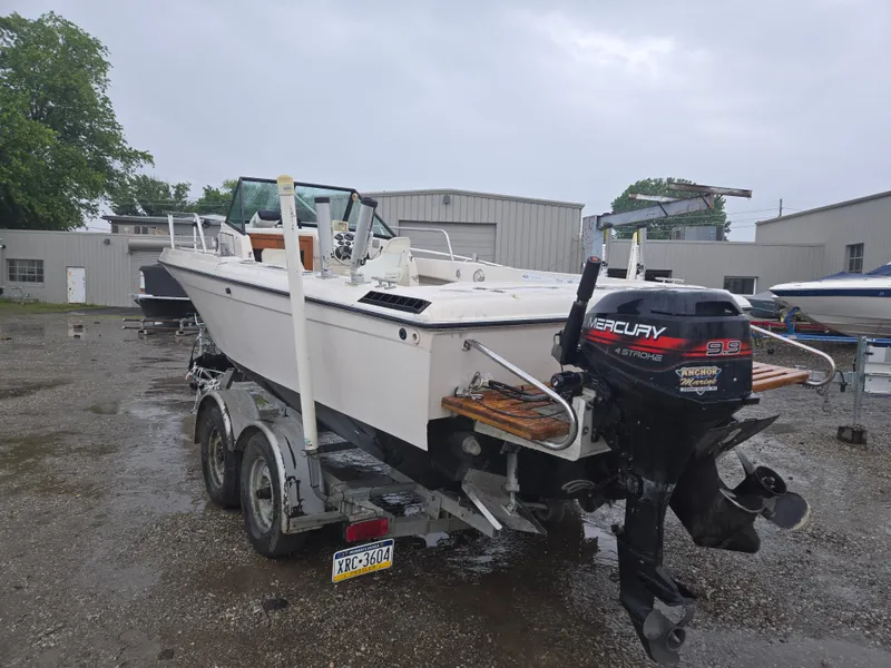 Slide: The Image of 1992 Dixie 21 boat on trailer with Mercury outboard motor, parked outdoors. - 5