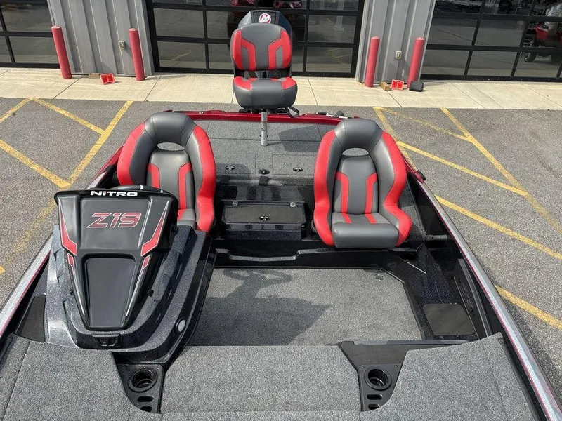 Slide: The Image of 2025 Nitro Z19 Pro boat with red and gray seating, parked outdoors. - 17