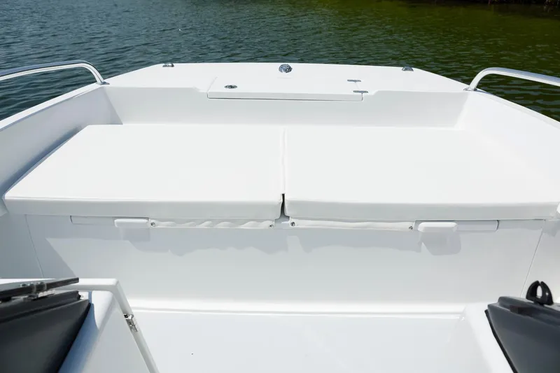 Slide: The Image of 2025 ArrowCat 20DC boat deck with white seating, on calm water. - 10