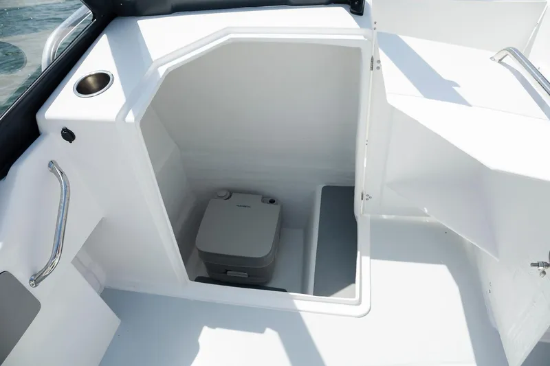 Slide: The Image of 2025 ArrowCat 20DC boat interior with compact toilet and seating area. - 3