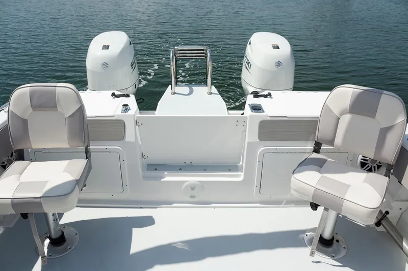 Slide: The Image of 2025 ArrowCat 20DC boat interior with dual engines and seating, on calm water. - 6