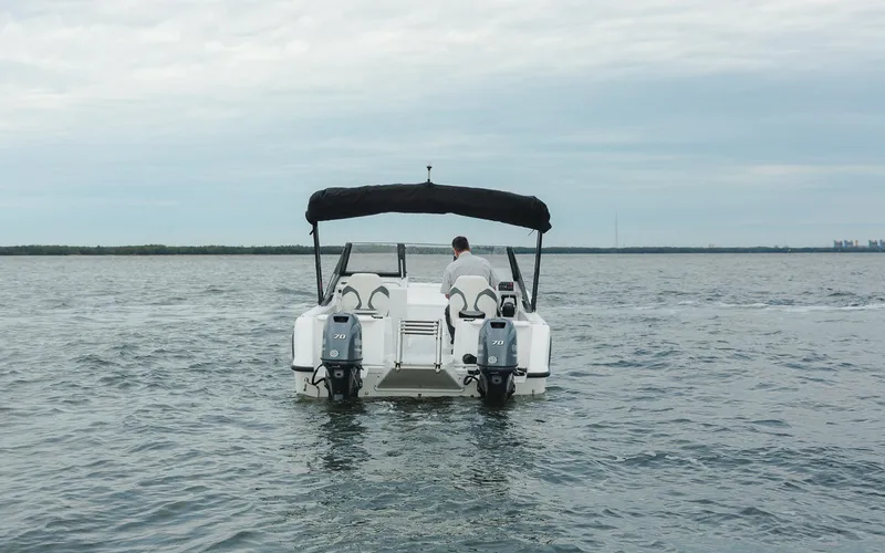 Slide: The Image of 2025 ArrowCat 20DC boat on open water, rear view with dual engines. - 7