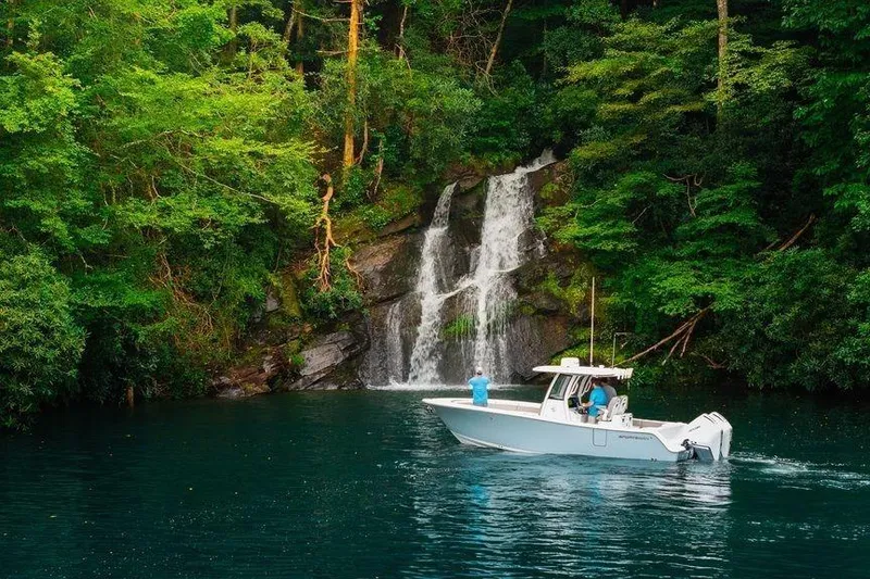 The Image of 2025 Sportsman OPEN 262 boat near a scenic waterfall in lush greenery. - 0