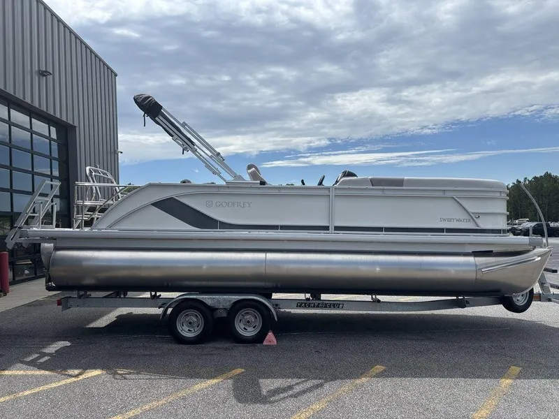 Slide: The Image of 2025 Godfrey SWEETWATER 2286 SFL pontoon boat on trailer, parked outdoors. - 5