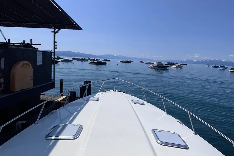 Slide: The Image of 2017 Formula 370 Super Sport boat docked, overlooking a serene lake with distant boats. - 10