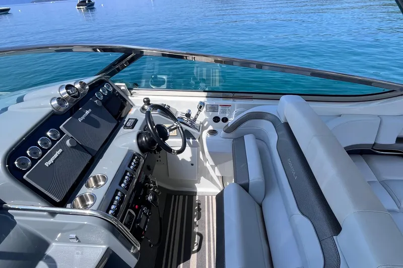 Slide: The Image of 2017 Formula 370 Super Sport boat cockpit with modern controls and seating, on calm blue water. - 14