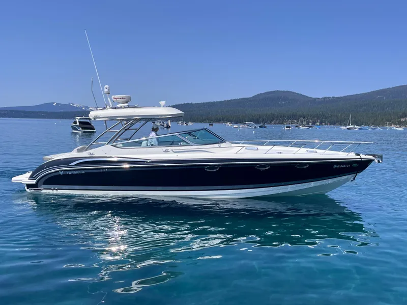 Slide: The Image of 2017 Formula 370 Super Sport boat on a clear blue lake with scenic mountain backdrop. - 7