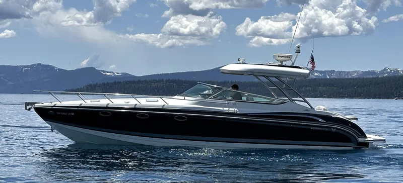 Slide: The Image of 2017 Formula 370 Super Sport boat cruising on a scenic lake under a cloudy sky. - 8