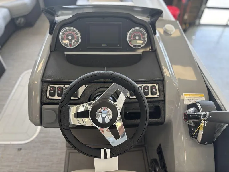 Slide: The Image of 2025 Godfrey Monaco 235 SFL boat dashboard with steering wheel and control panel. - 19