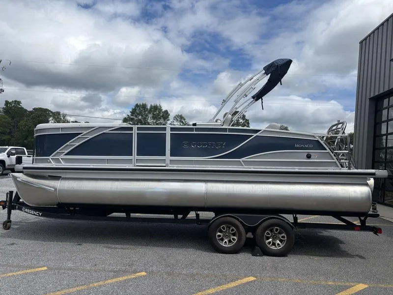 Slide: The Image of 2025 Godfrey Monaco 235 SFL pontoon boat on trailer, parked outdoors. - 6