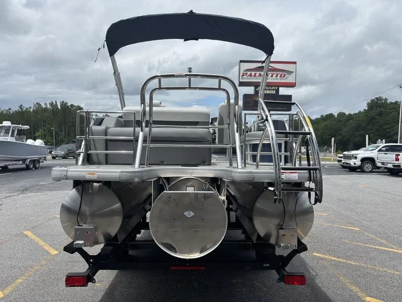 Slide: The Image of 2025 Godfrey Monaco 235 SFL pontoon boat, rear view, parked outdoors under cloudy sky. - 7