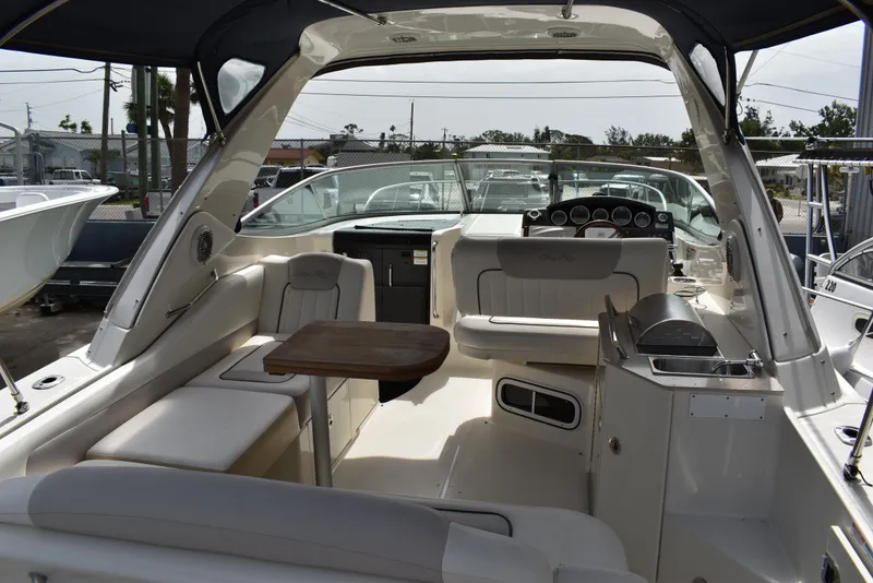 Slide: The Image of 2011 Sea Ray 310 Sundancer boat interior with seating, table, and helm. - 11