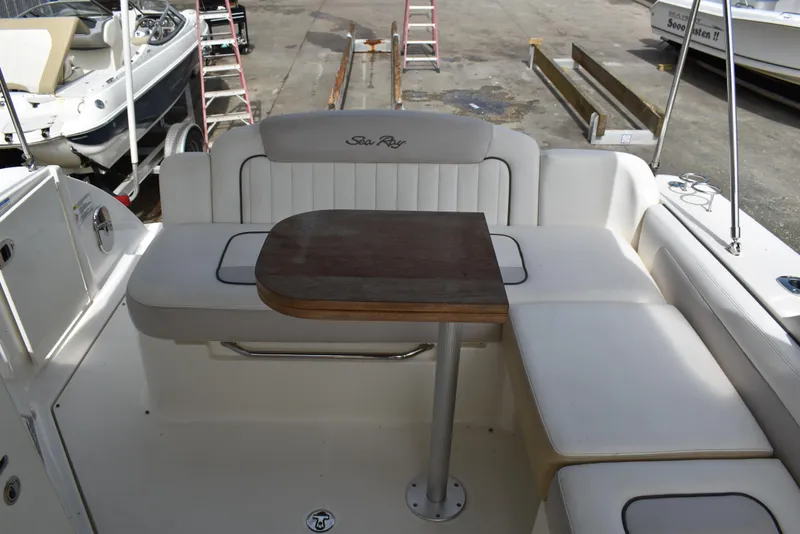 Slide: The Image of 2011 Sea Ray 310 Sundancer boat interior with seating and wooden table. - 12