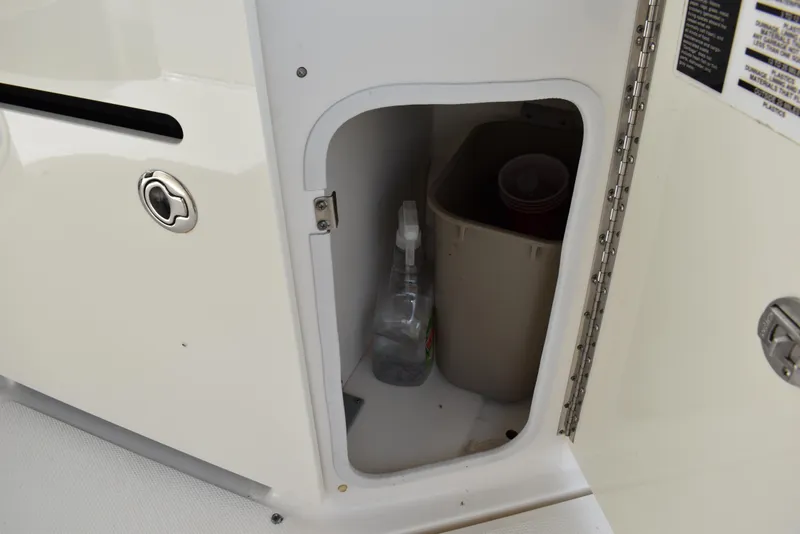 Slide: The Image of Storage compartment on a 2011 Sea Ray 310 Sundancer boat with cleaning supplies. - 15