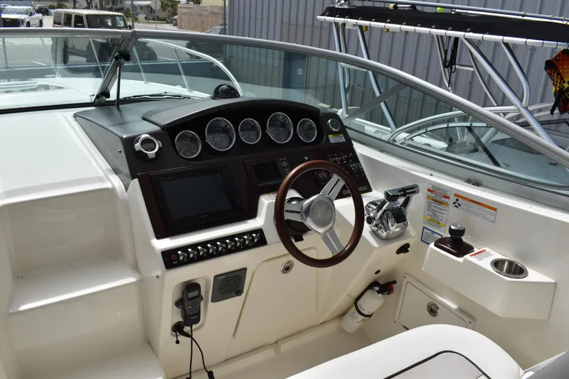 Slide: The Image of Cockpit of 2011 Sea Ray 310 Sundancer with steering wheel and control panel. - 19