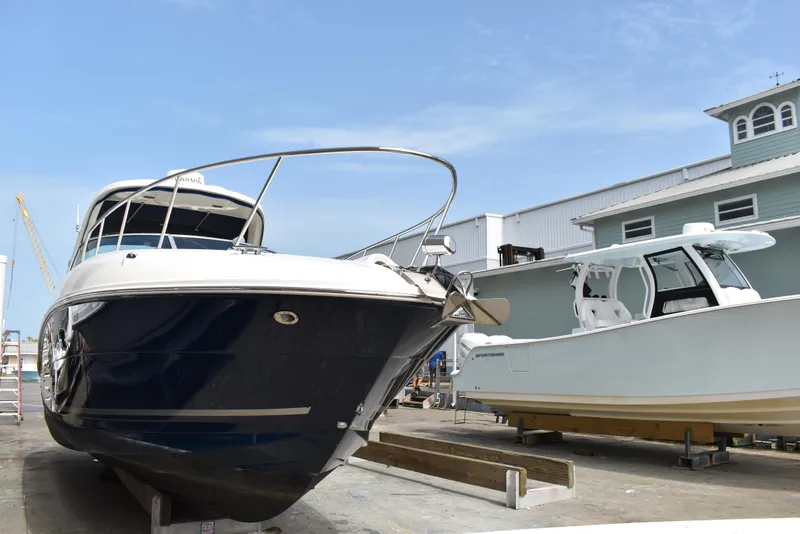 Slide: The Image of 2011 Sea Ray 310 Sundancer yacht on dry dock beside another boat. - 2